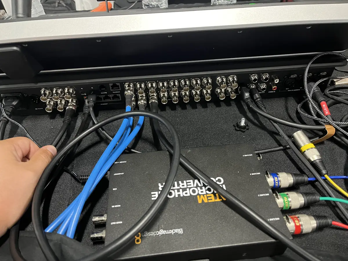 Hand routing Ethernet and audio cables into the back of a video switcher and a Blackmagic ATEM microphone converter